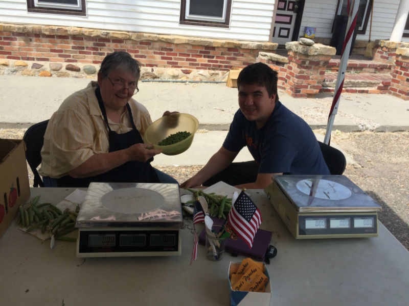 Pat and grandson Cetan shelling peas at the Douglas stand.